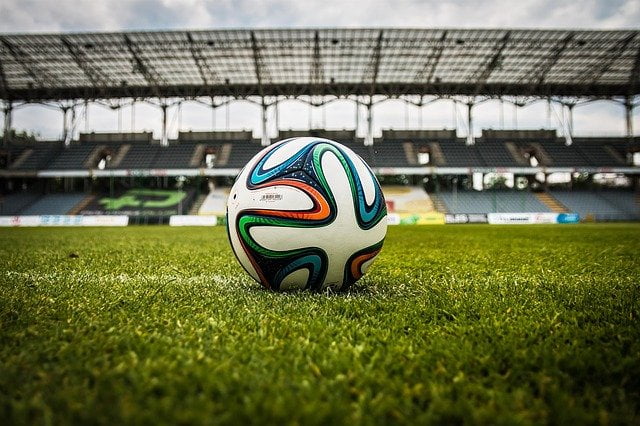 Soccer ball in stadium by pixabay user jarmoluk